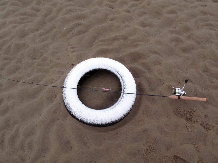 Изображение Автомобильная покрышка – удобное место на пляже чтобы положить спиннинг. Фото: Коломийца Алексея. 