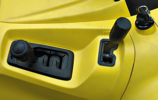 Изображение Коробка передач имеет четыре режима: R — реверс, N — нейтраль, H — повышенная передача, L — «понижайка». Подключение полного привода происходит жестко с помощью рычага, расположенного чуть впереди селектора КП. 