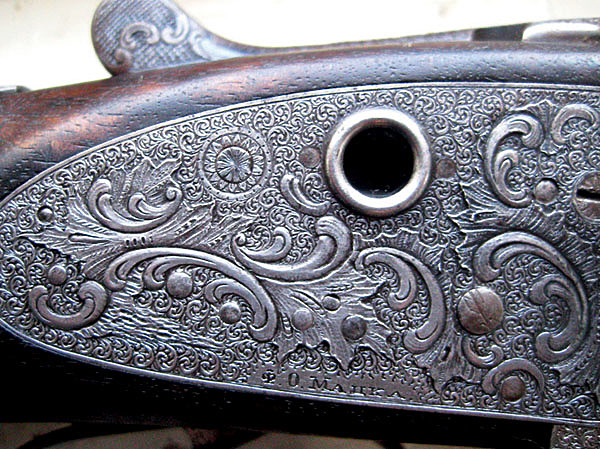 Изображение Оригинальный флористический орнамент в технике высокорельефной гравировки в обрамлении мелких арабесок на боковой доске бескуркового ружья из частного собрания. Замки ложноподкладные типа bar-action sidelock Скотта с «хрустальными окошками» (Crystal cocking indicator). ФОТО ИЗ АРХИВА ЮРИЯ МАСЛОВА И И.Б. БЕЛЯЕВА